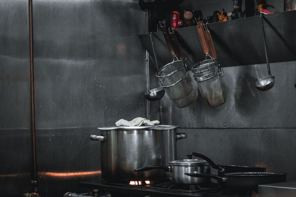 Stainless steel wall, pots and utensil rail in a commercial kitchen
