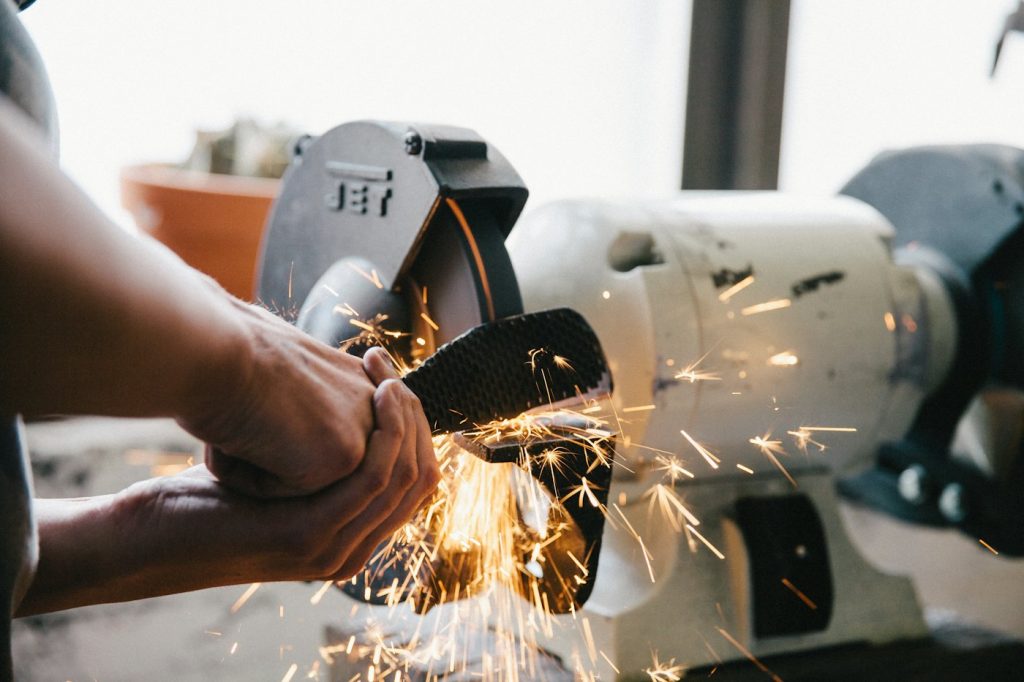 Grinding and finishing steel with a bench grinder, sparks flying